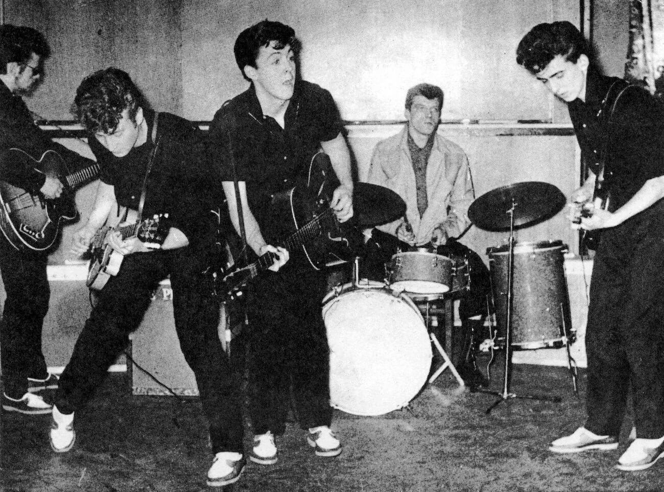 Paul McCartney and John Lennon performing with George Harrison in 1960. 