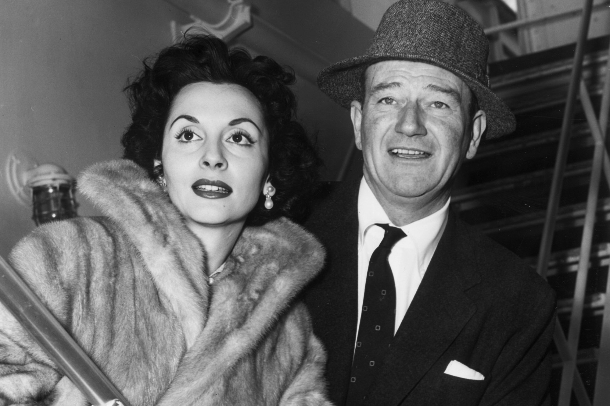 Pilar Palette and John Wayne, who was 'obsessed' with Latin women. In a black-and-white picture, she's in a fur and he's wearing a suit and tie