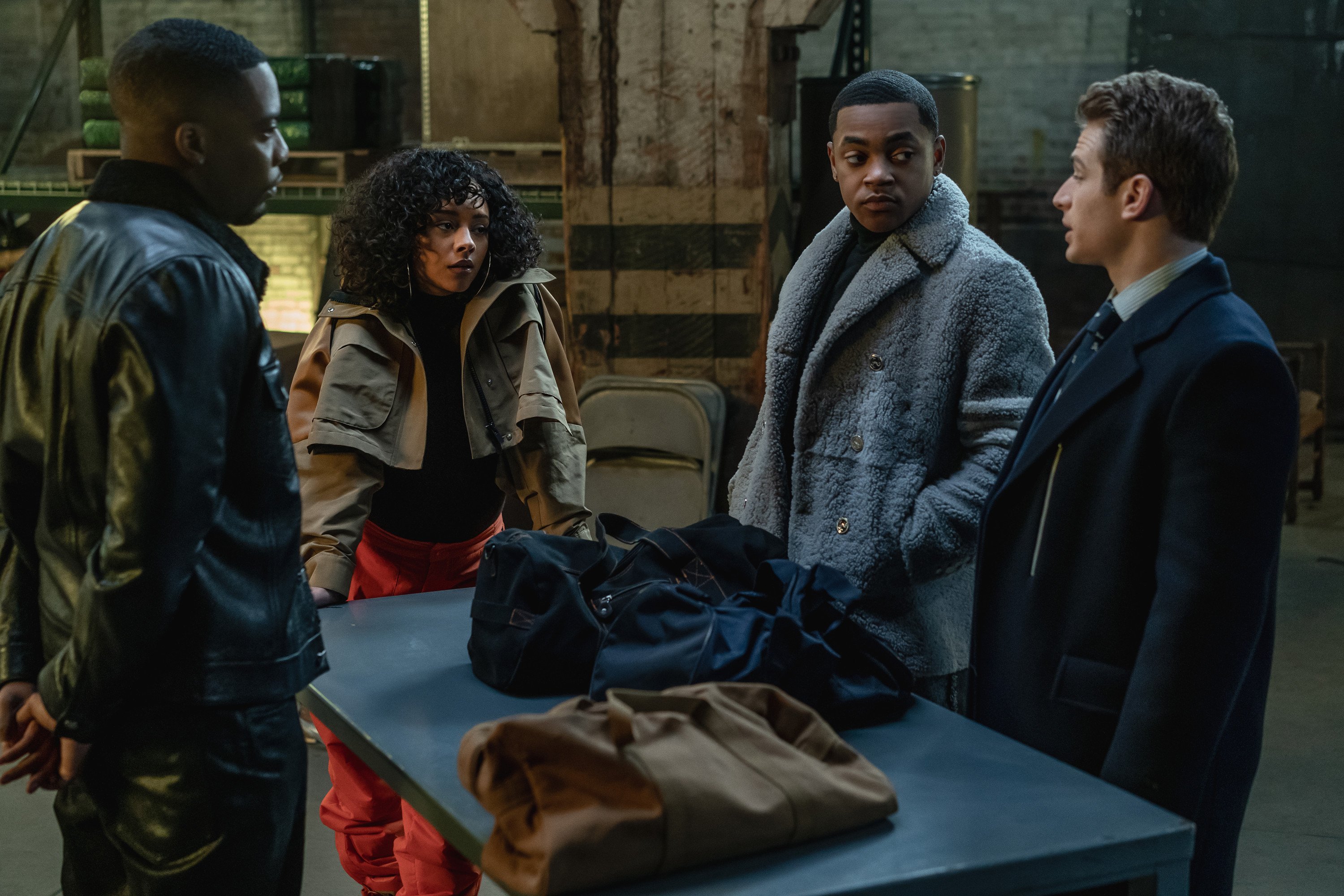 Woody McClain as Cane Tejada, Alix Lapri as Effie Morales, Michael Rainey Jr. as Tariq St. Patrick and Gianni Paolo as Brayden Weston standing around a table conversing in 'Power Book II: Ghost'