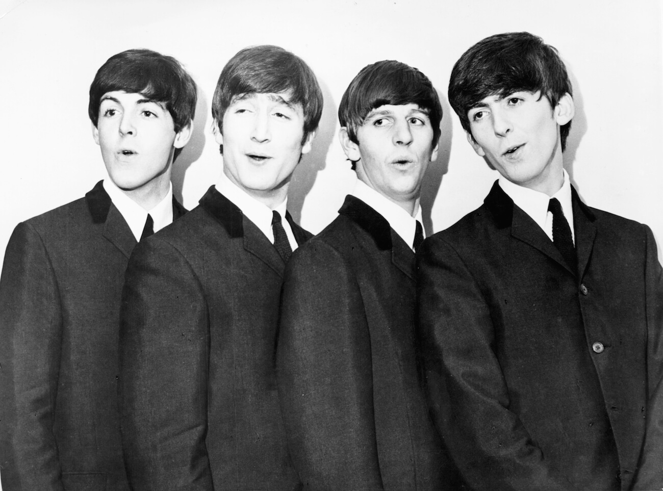 The Beatles posing in black suits in 1964.