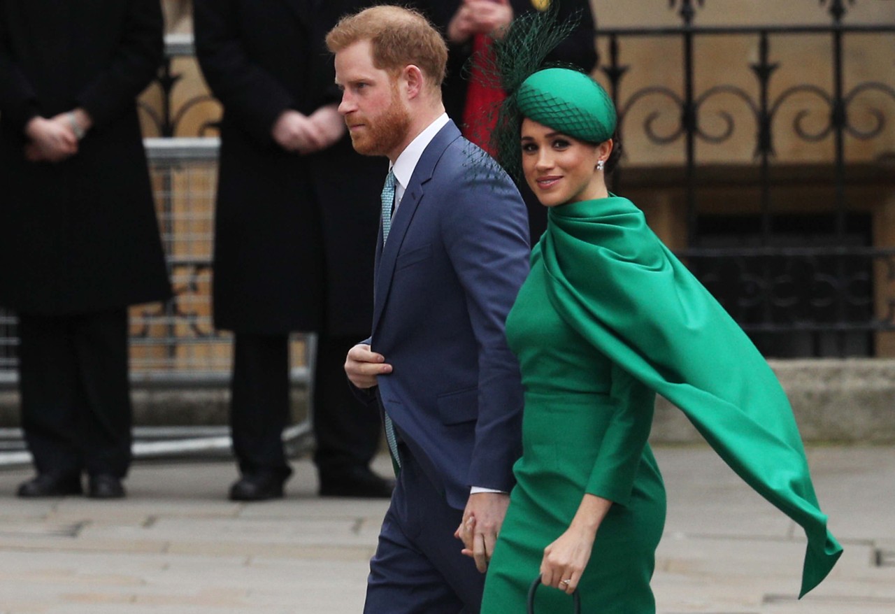 Prince Harry and Meghan Markle walk together during an event.