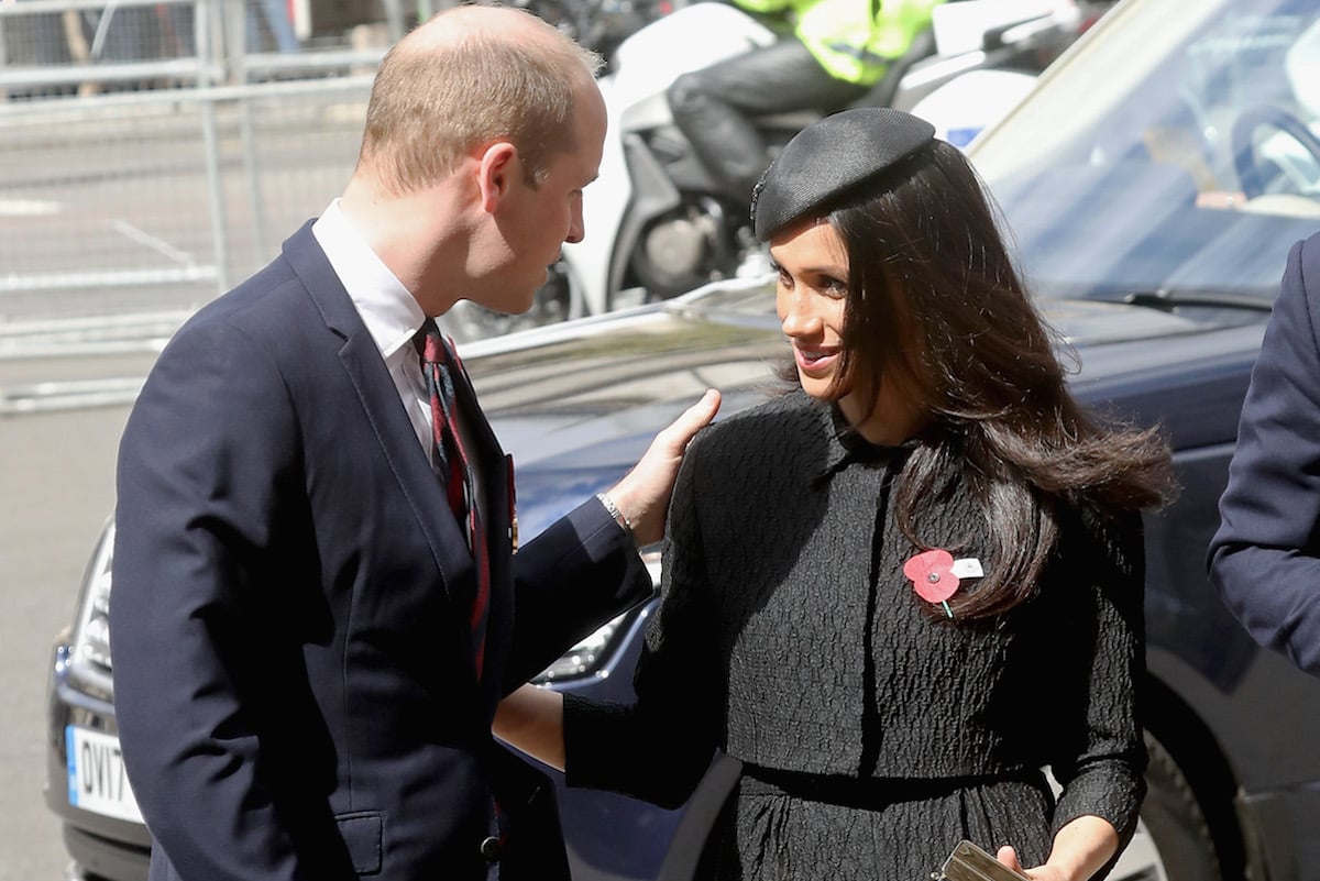 Prince William, who was 'completely freaked' when Meghan Markle hugged him when they first met, according to Prince Harry's 'Spare', touches Meghan Markle's arm