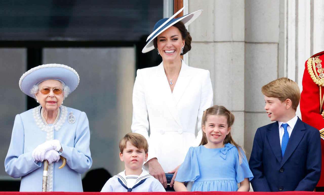(l-r) Queen Elizabeth II, Prince Louis, Kate Middleton, Princess Charlotte, and Prince George watch a flypast from the balcony of Buckingham Palace during Trooping the Colour on June 2, 2022.