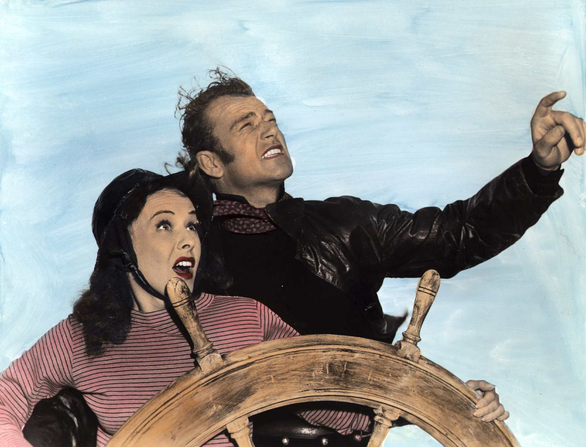 'Reap the Wild Wind' Paulette Goddard as Loxi Claiborne and John Wayne as Captain Jack Stuart, the first of his character deaths. They're standing behind the ship wheel looking shocked.