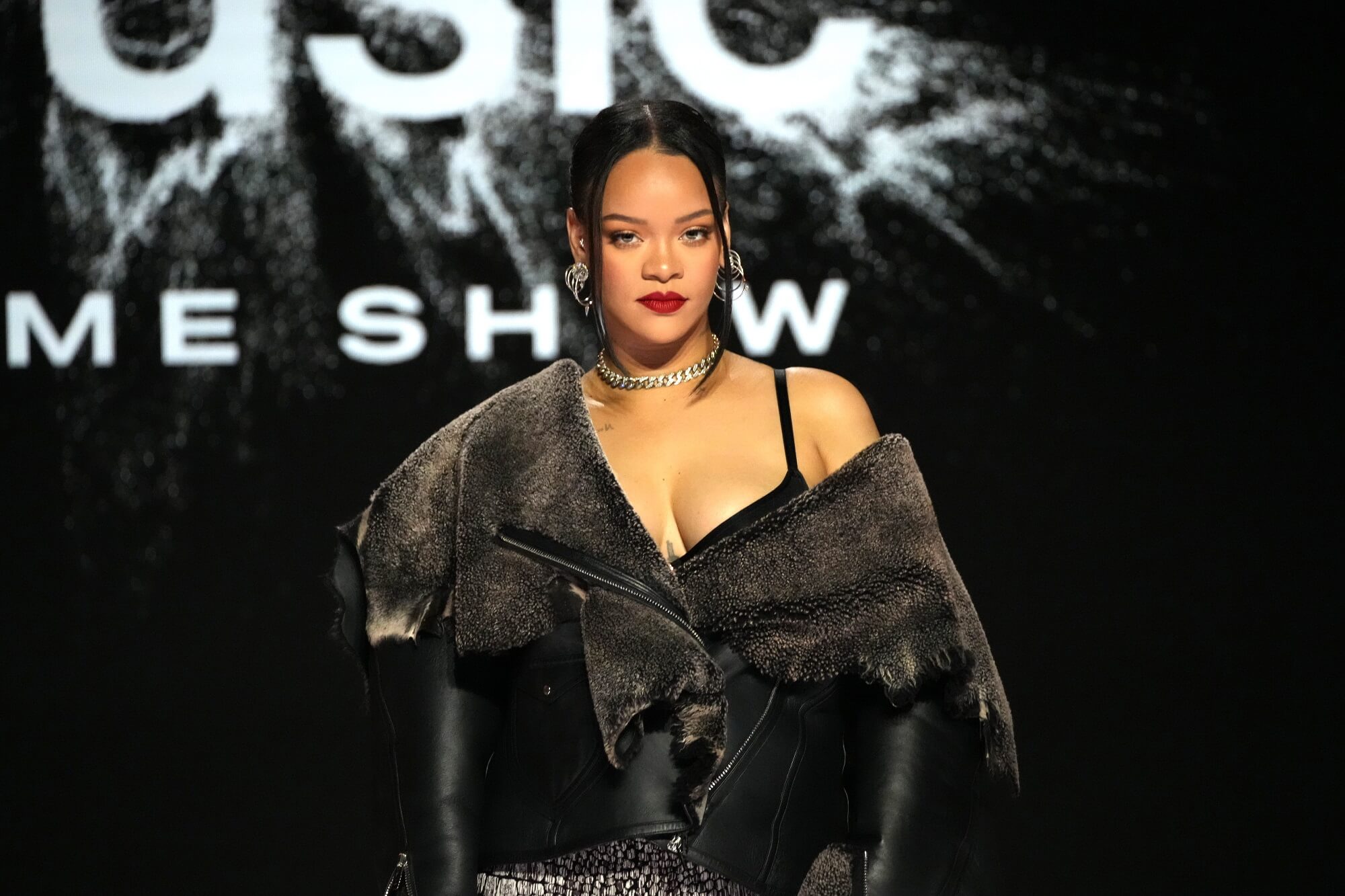 Rihanna looks into the camera while wearing a black outfit