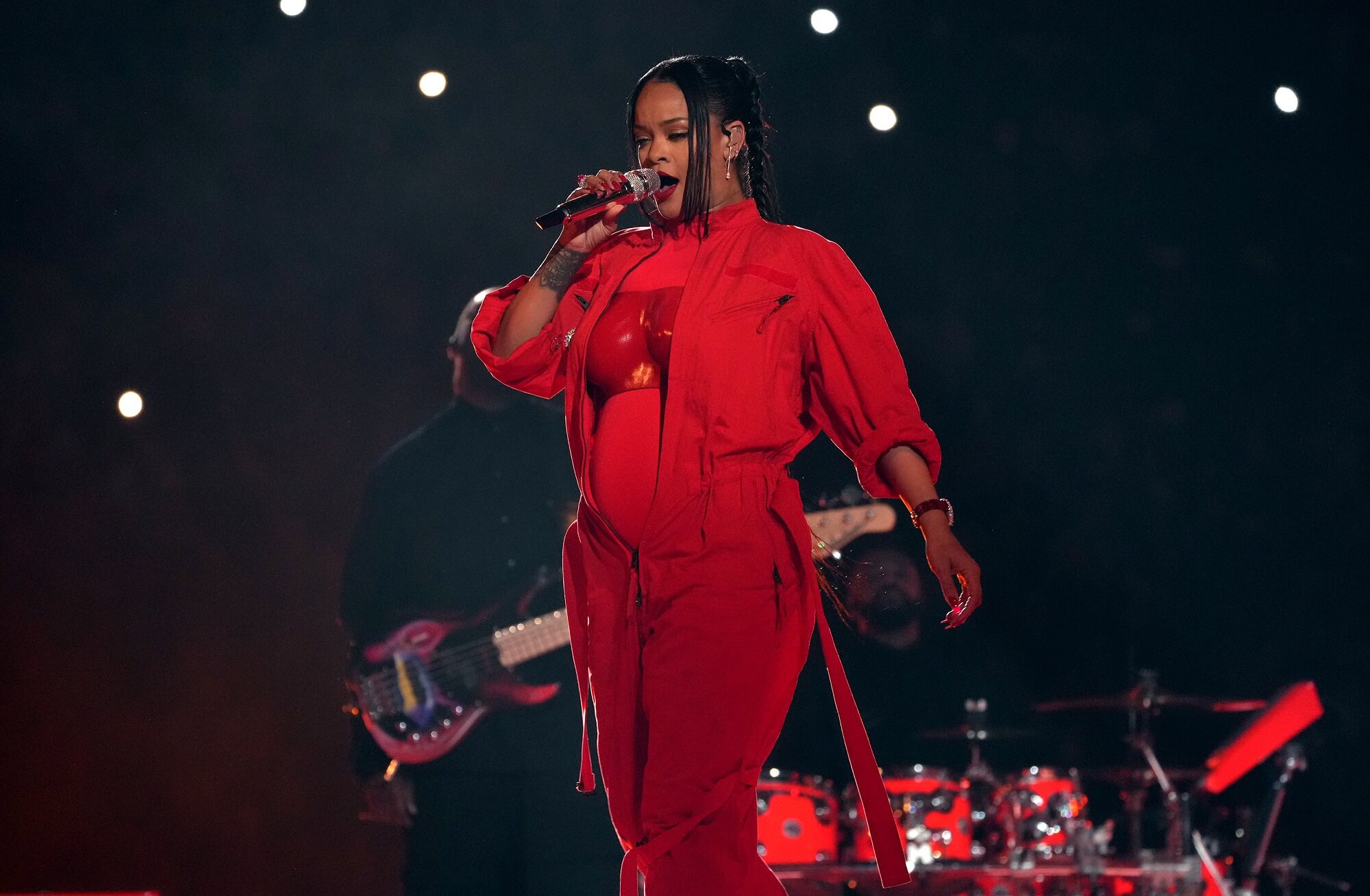 Rihanna performs onstage wearing a bright red outfit