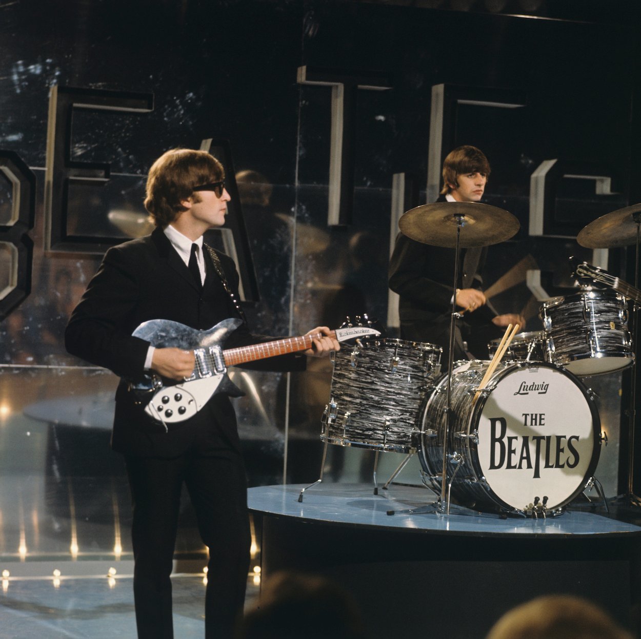 John Lennon (left) and Ringo Starr during a Beatles TV performance in 1964.
