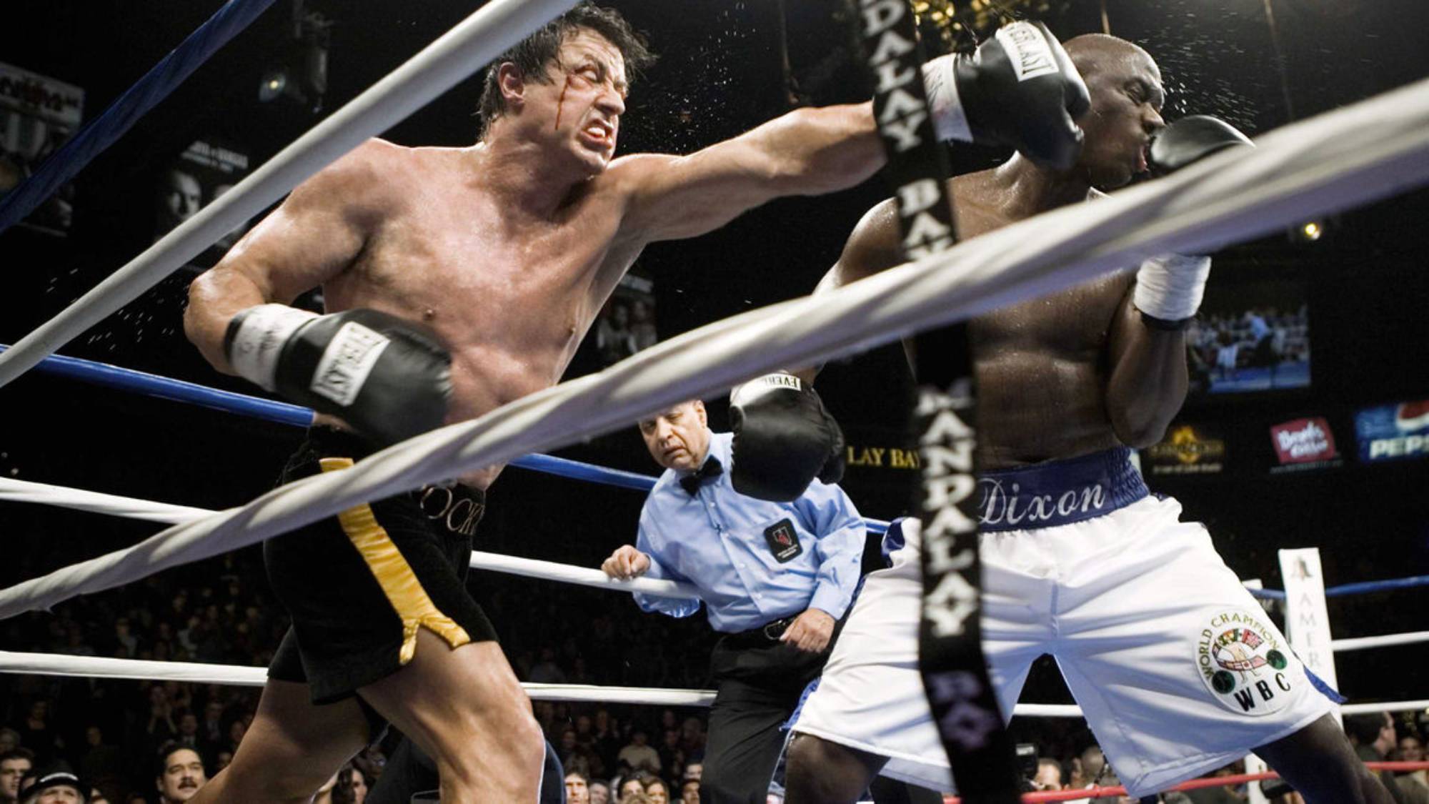 'Rocky Balboa' Sylvester Stallone as Rocky and Antonio Tarver as Mason 'The Line' Dixon. Rocky punches Mason in the face, while they're both wearing black boxing gloves in the ring.