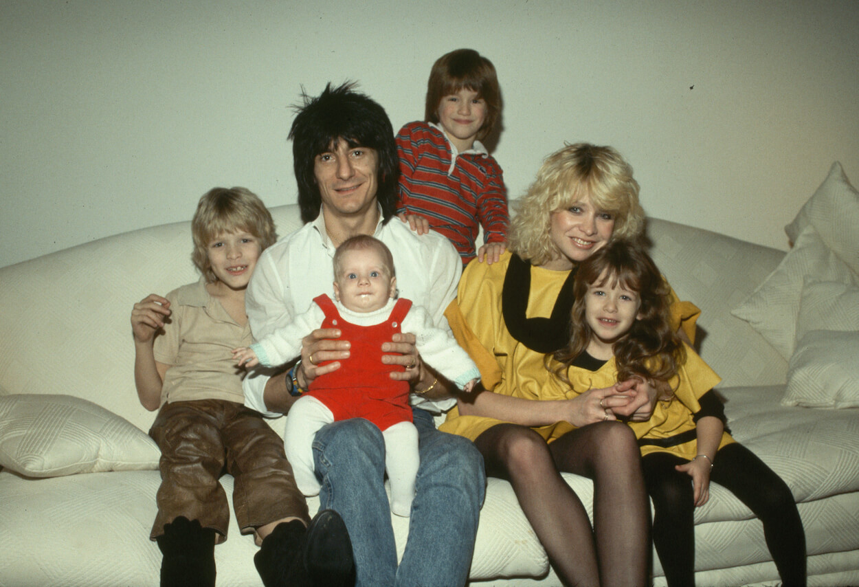 Rolling Stones guitarist Ronnie Wood, his girlfriend Jo Howard, and their children, including's Wood's son with his first wife sitting on a couch circa 1985.