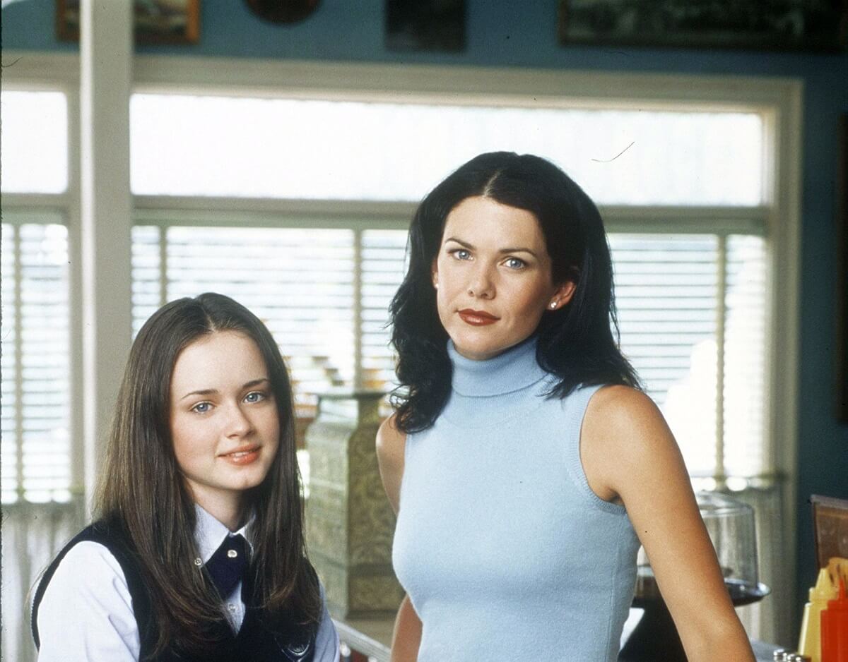 Alexis Bledel (as Rory) wears a school uniform while standing next to Lauren Graham (as Lorelai Gilmore) in Luke's Diner