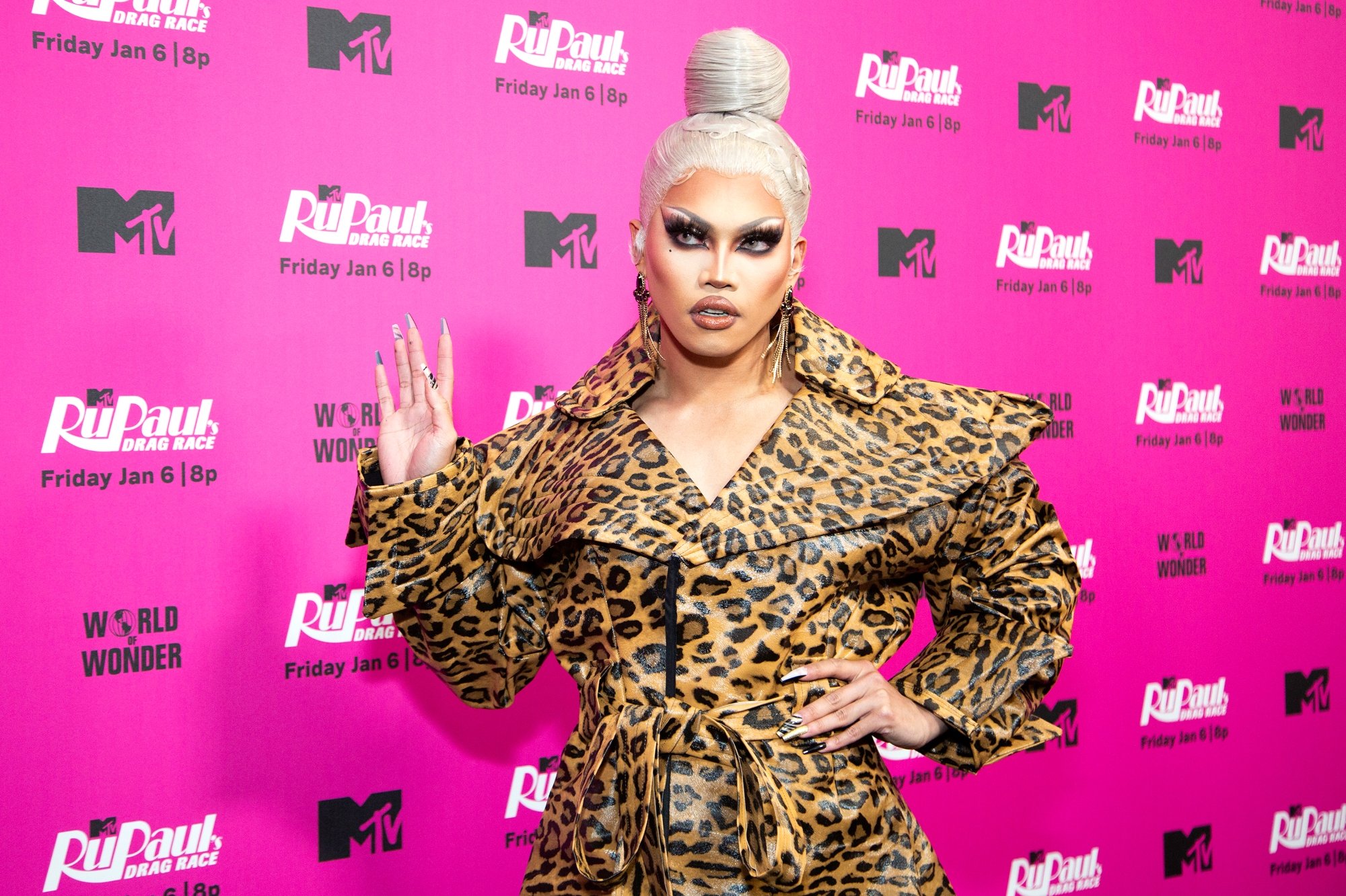 'RuPaul's Drag Race' Season 15 Aura Mayari holding her hand up in front of a pink step and repeat