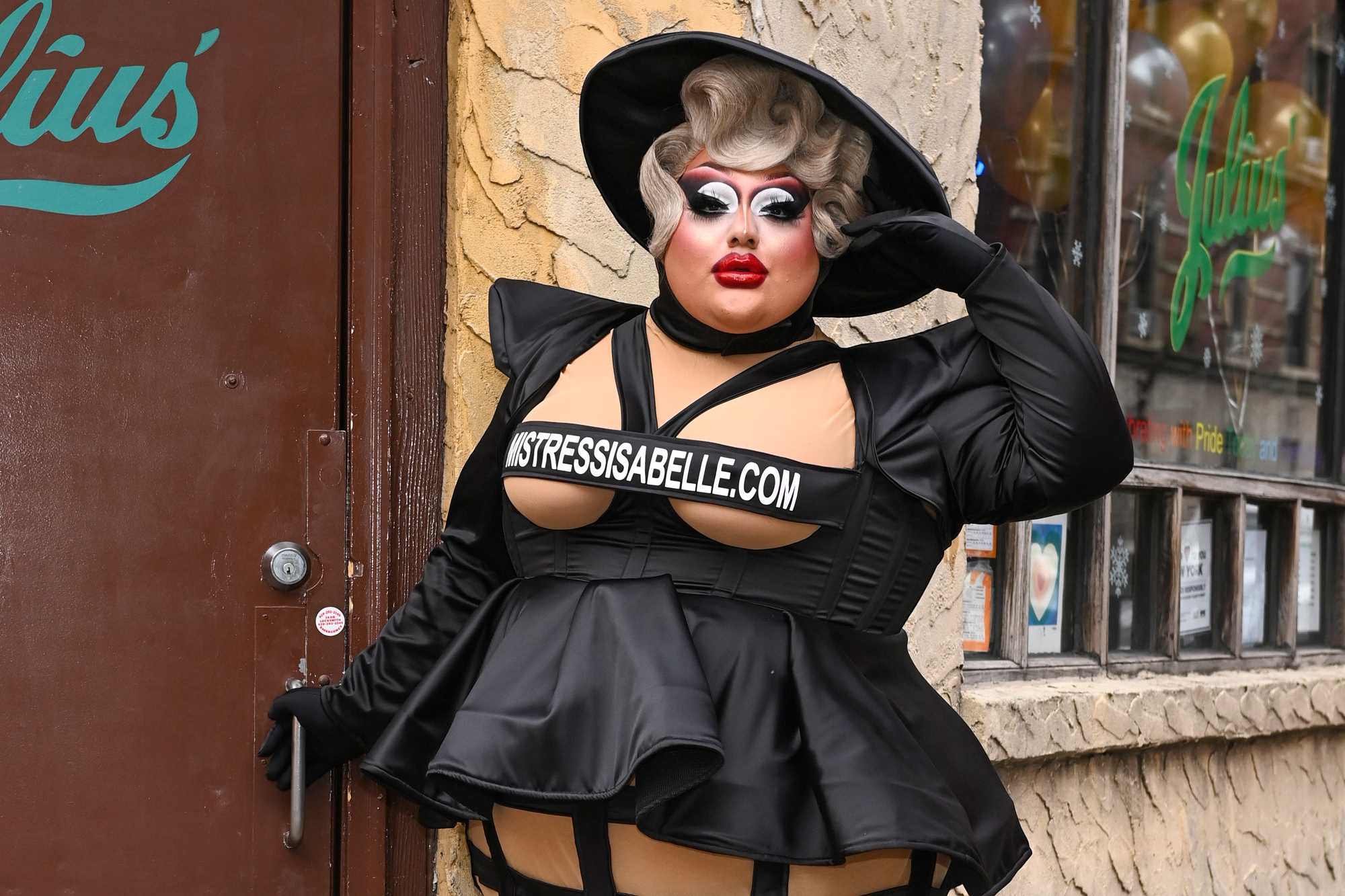 'RuPaul's Drag Race' Season 15 queen Mistress Isabelle Brooks posing in a black costume standing in front of Julius' Bar 