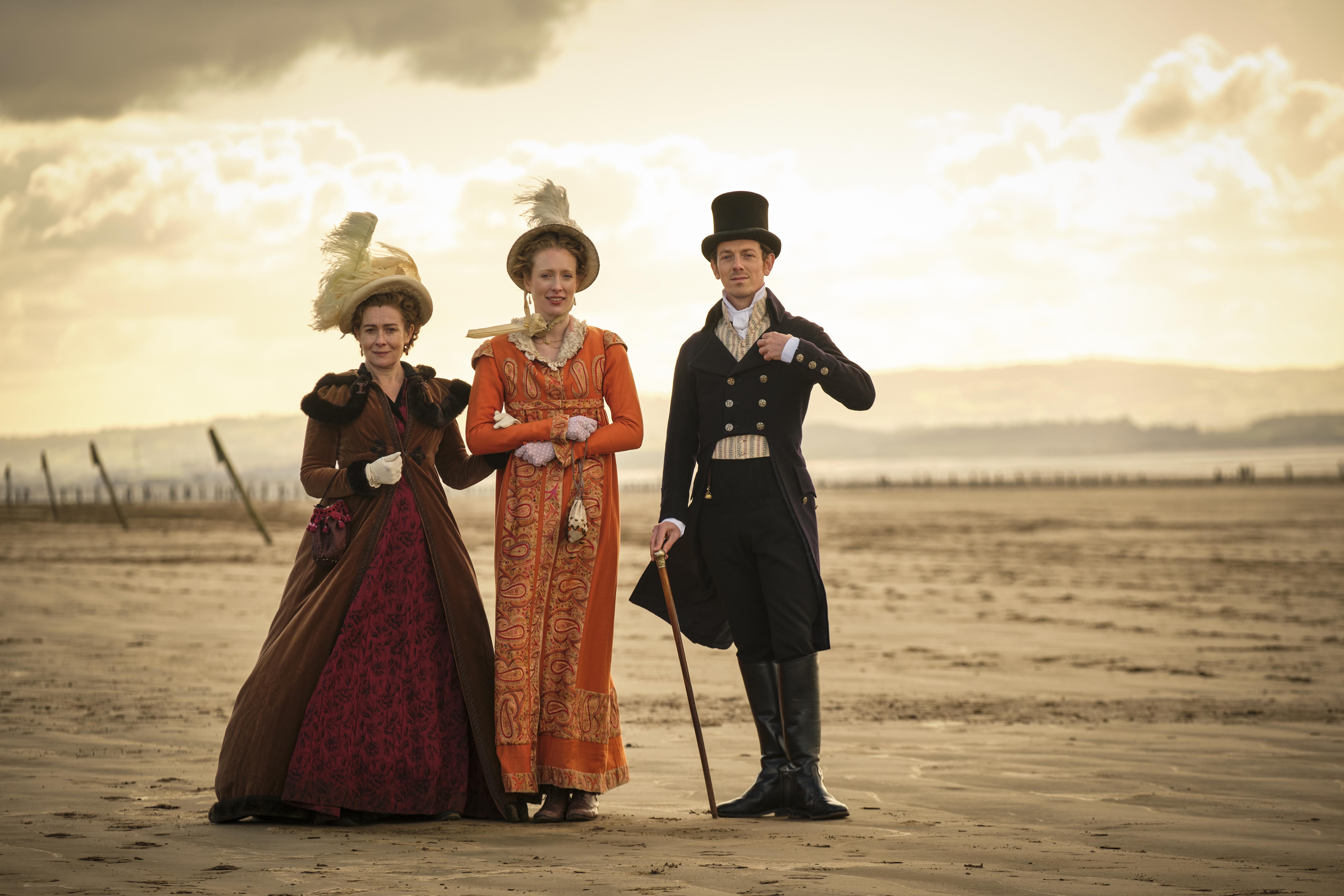 Three people in regency-era dress standing on a beach in 'Sanditon' Season 3
