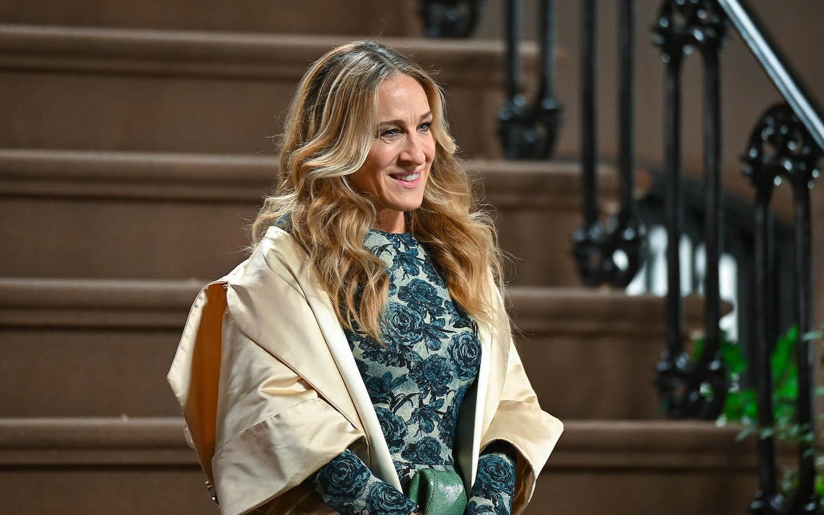 Sarah Jessica Parker smiling, standing on a stoop