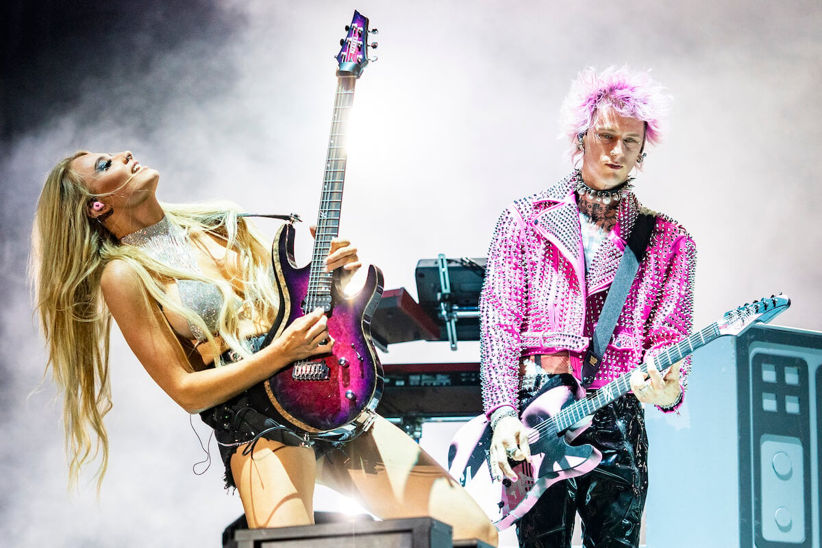 Guitar player Sophie Lloyd and Machine Gun Kelly perform on stage.