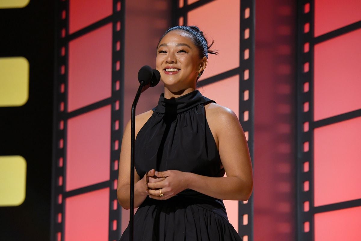 Stephanie Hsu speaks into a microphone at an awards ceremony.