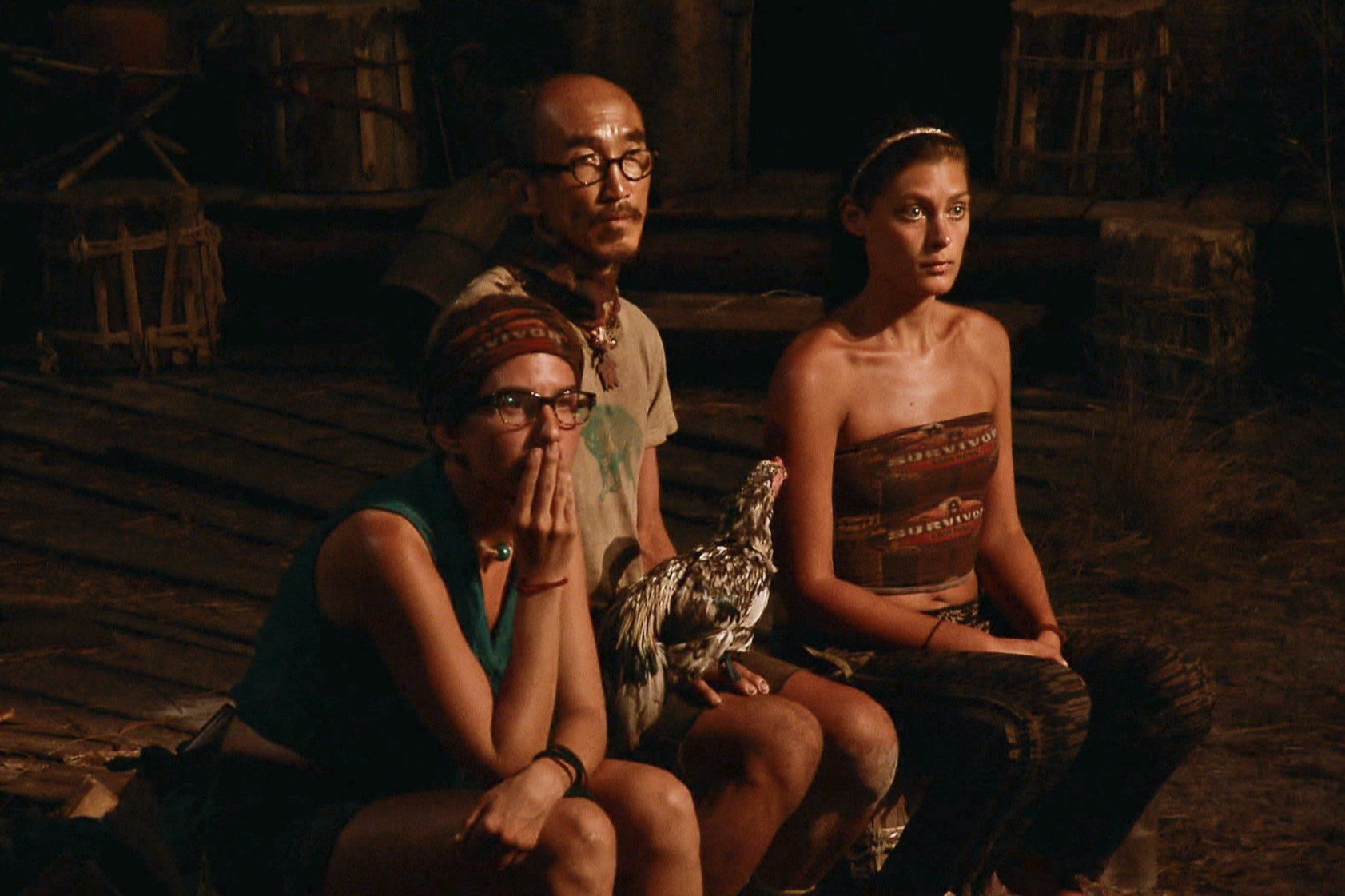 Aubry Bracco, Tai Trang, and Michele Fitzgerald, who was the 'Survivor' Season 32 winner, appear at the Final Tribal Council. Aubry wears a teal shirt and jean shorts. Tai wears a tan shirt and dark brown shorts. Michele wears her brown 'Survivor' buff as a shirt and dark pants.