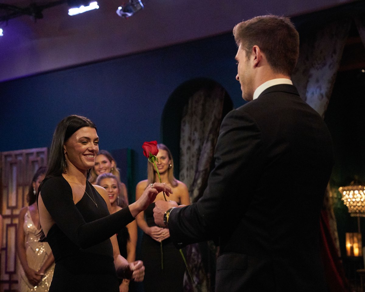 During The Bachelor 2023, Gabi Elnicki receives a rose from Zach Shallcross. She is wearing a black dress.