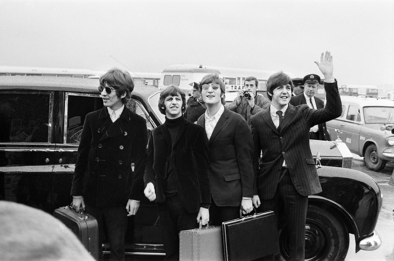 The Beatles arriving in the U.S. in black suits in 1966.