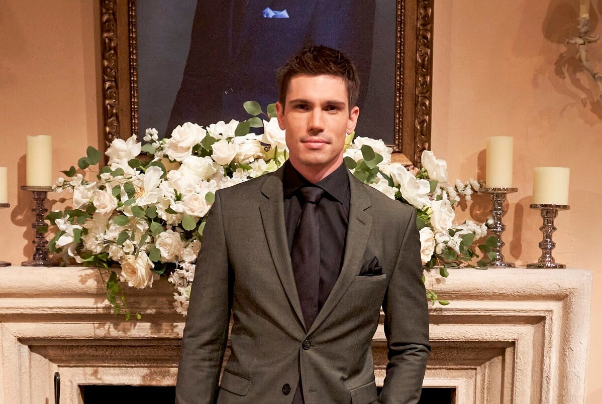 'The Bold and the Beautiful' star Tanner Novlan dressed in a grey suit; posing on set of the soap opera.