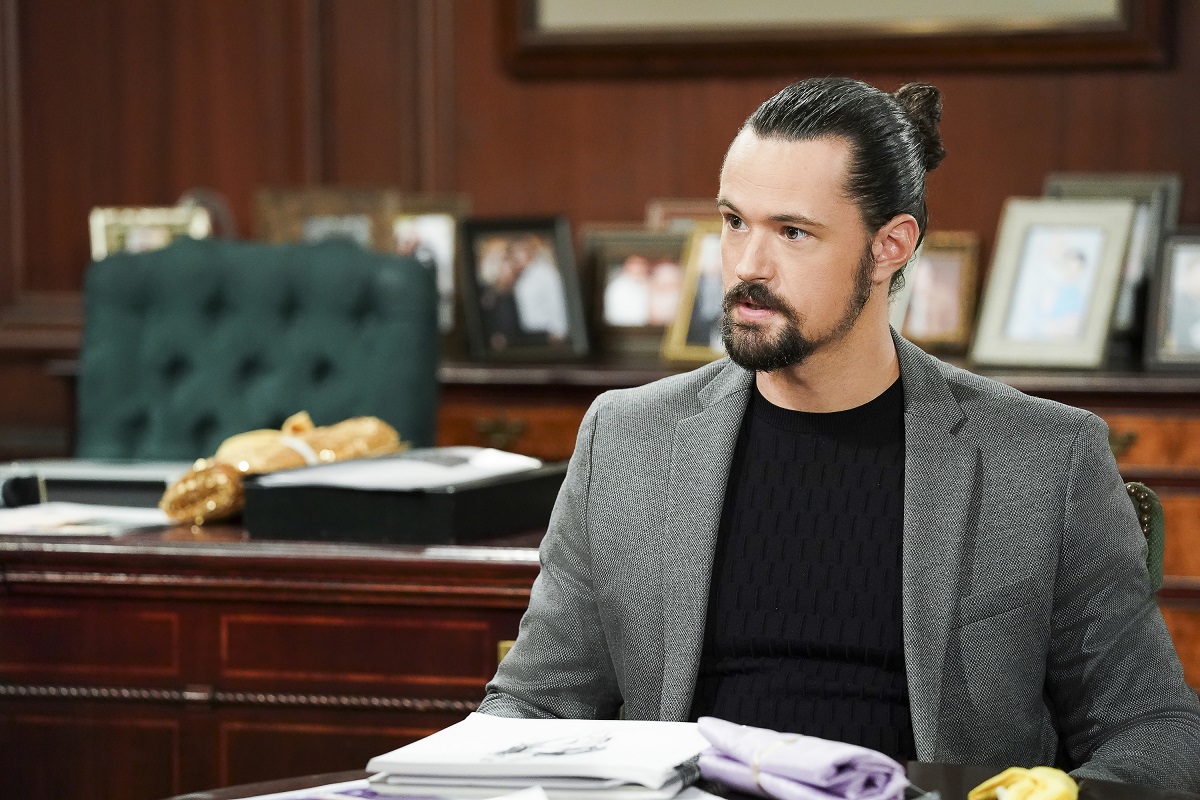 'The Bold and the Beautiful' star Matthew Atkinson dressed in a grey suit and black shirt; sitting in the Forrester Creations office set.