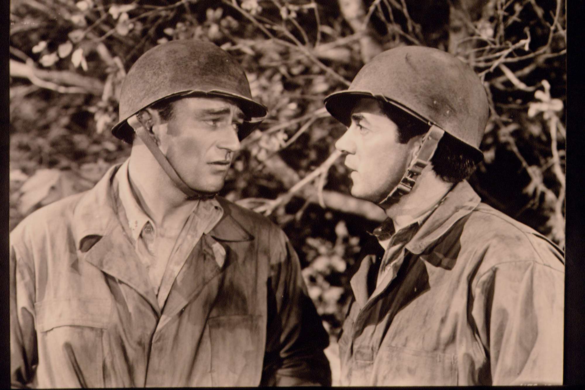 'The Fighting Seabees' John Wayne as Lt. Cmdr. Wedge Donovan in a sepia-toned picture, looking surprised