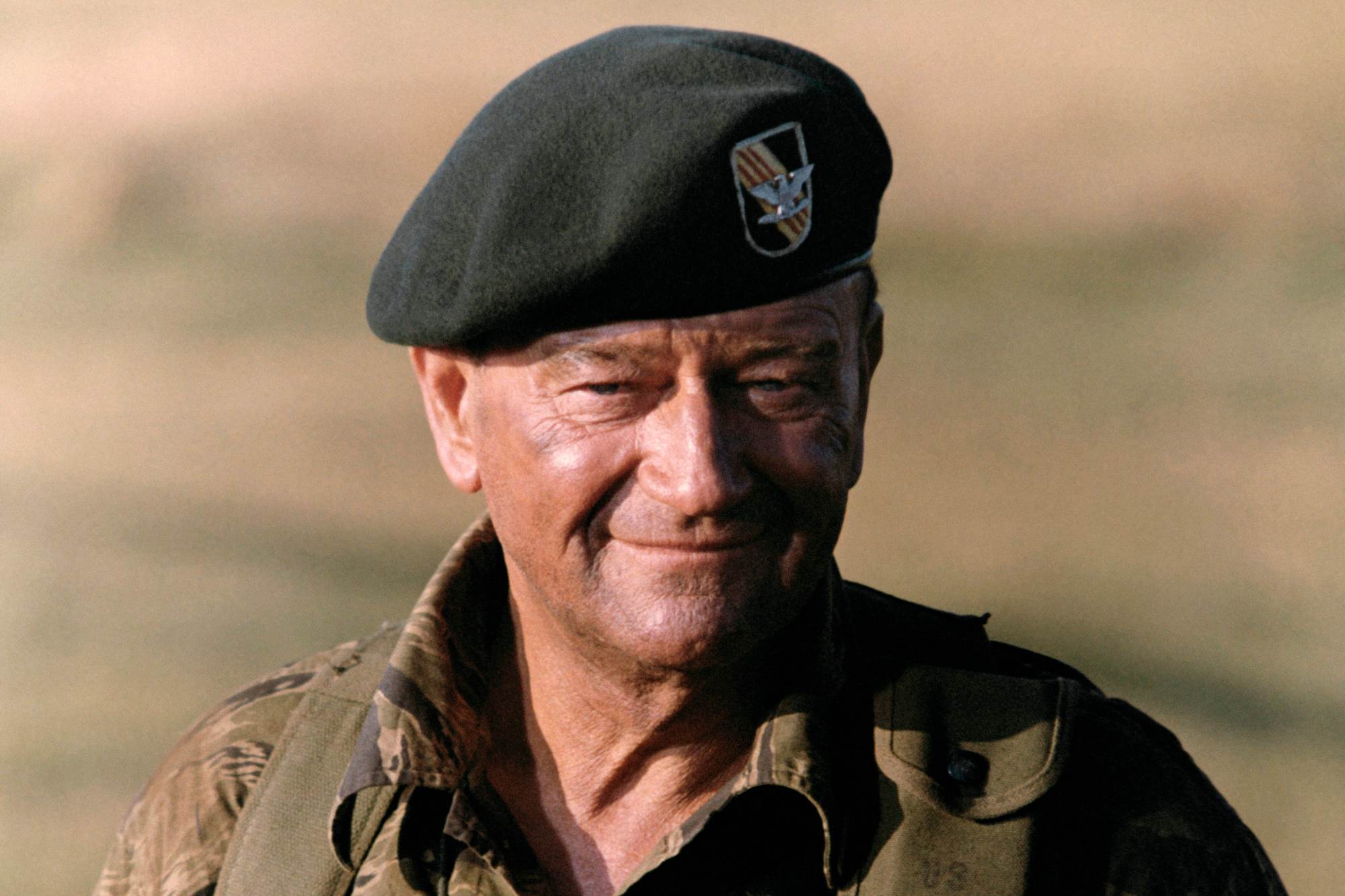 'The Green Berets' John Wayne as Col. Mike Kirby with a slight smile on his face, wearing a beret uniform