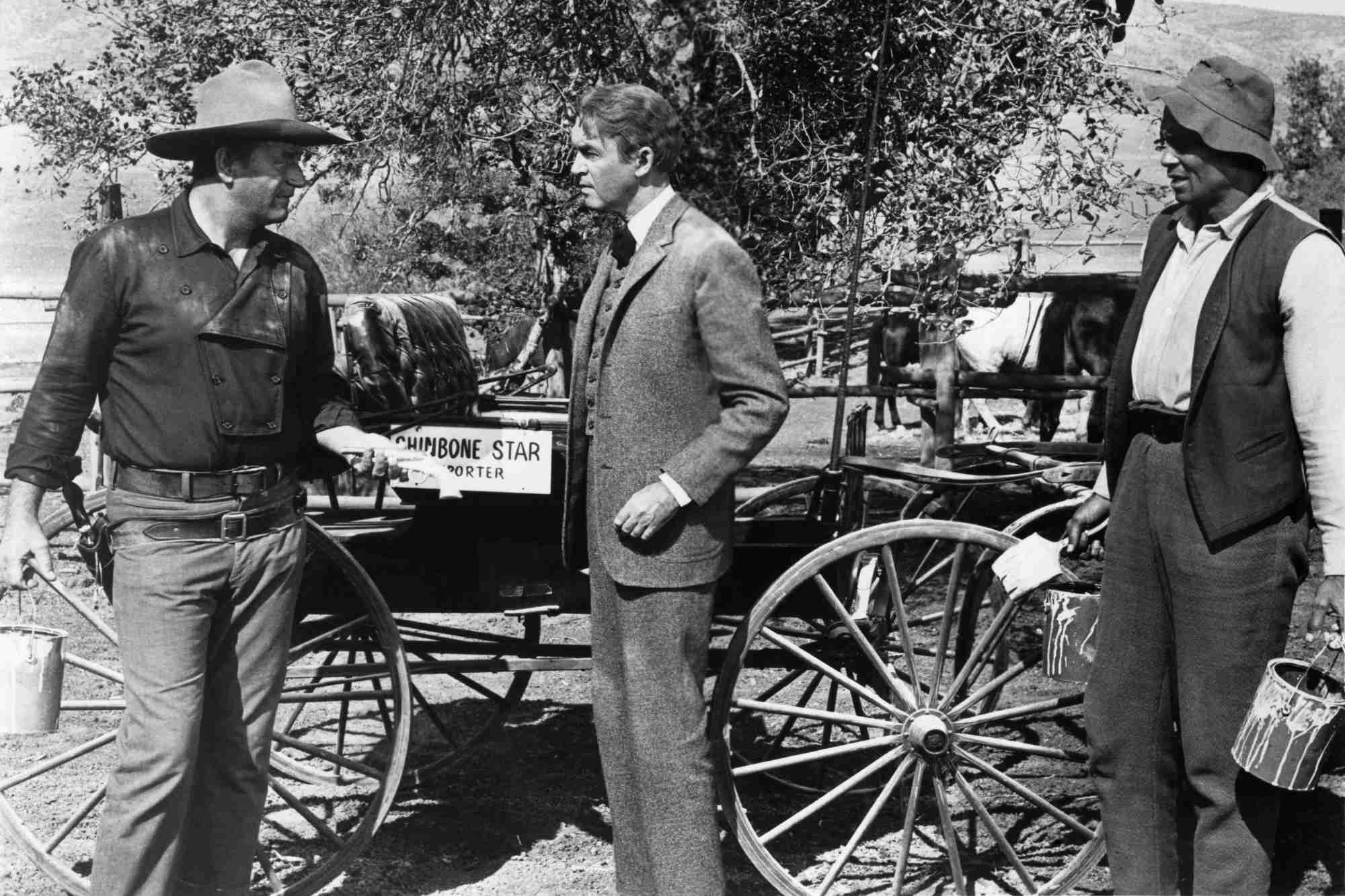 'The Man Who Shot Liberty Valance' John Wayne as Tom Doniphon, James Stewart as Ransom Stoddard, and Woody Strode as Pompey. Wayne and Stewart looking at one another frustrated, while Strode looks at them.