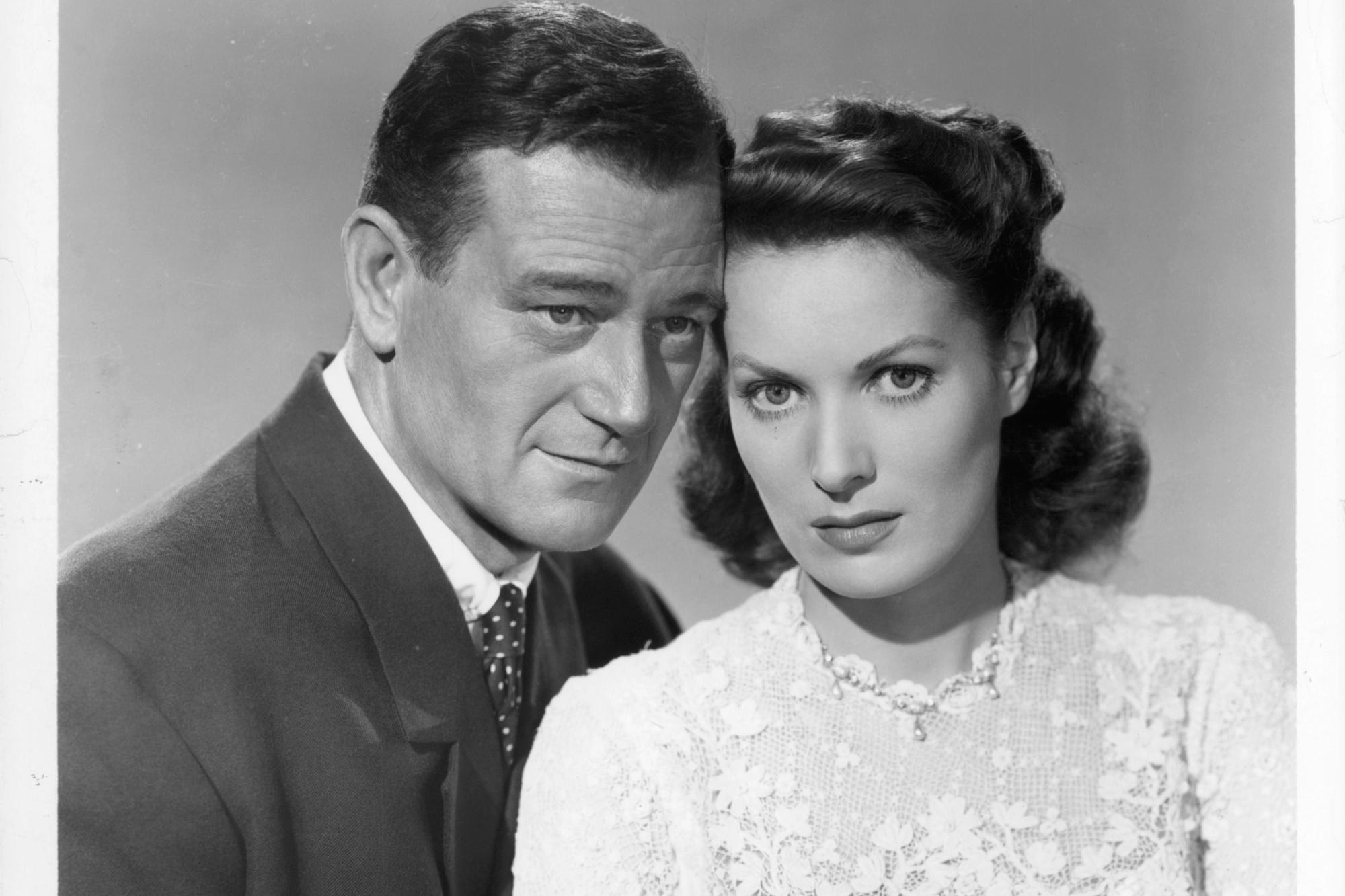 'The Quiet Man' John Wayne and Maureen O'Hara in a promotional black-and-white photo, with their heads touching