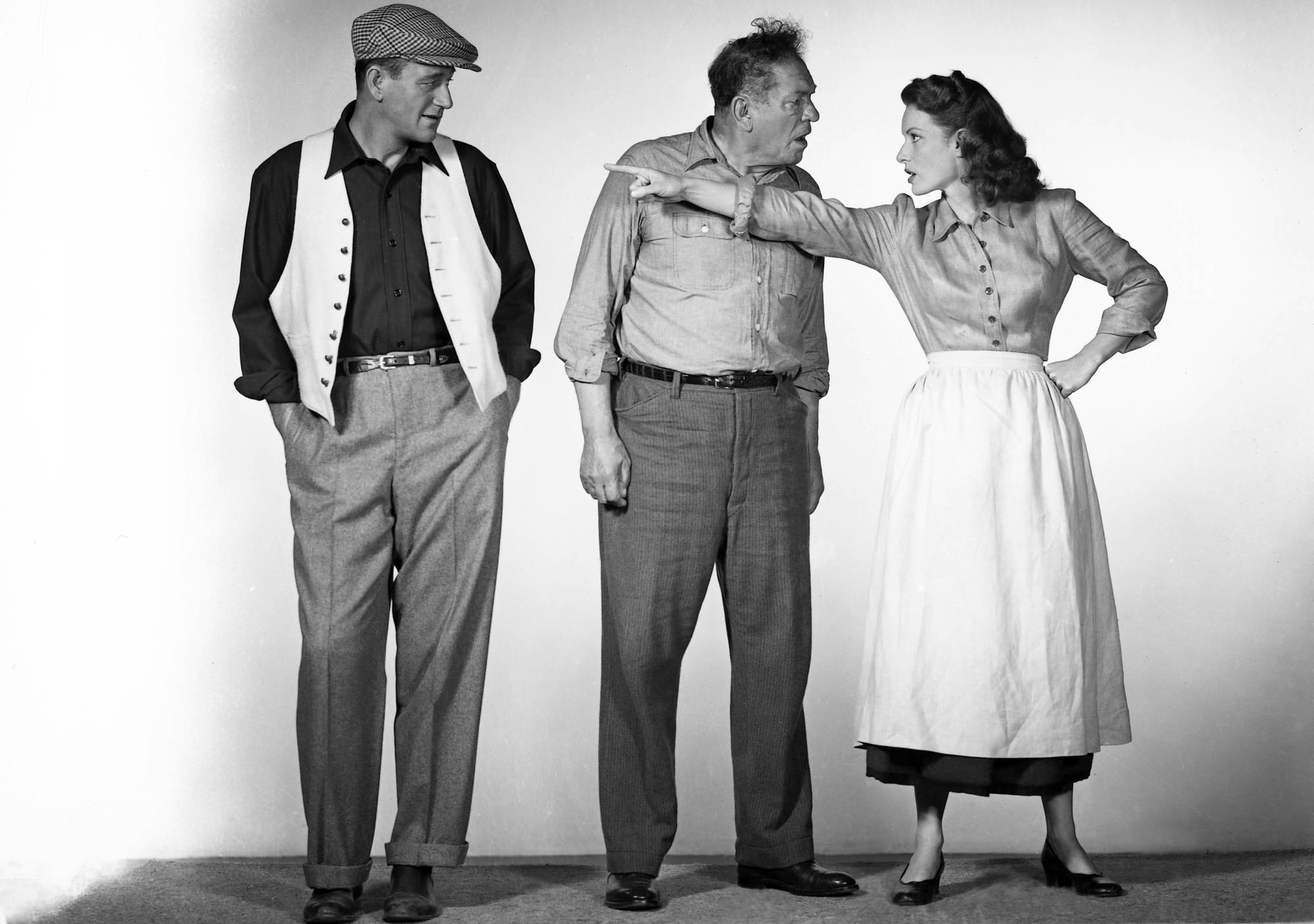 'The Quiet Man' John Wayne as Sean Thornton, Victor McLaglen as Squire 'Red' Will Danaher, and Maureen O'Hara as Mary Kate Danaher. O'Hara is pointing at Wayne, while McLaglen is looking at O'Hara.