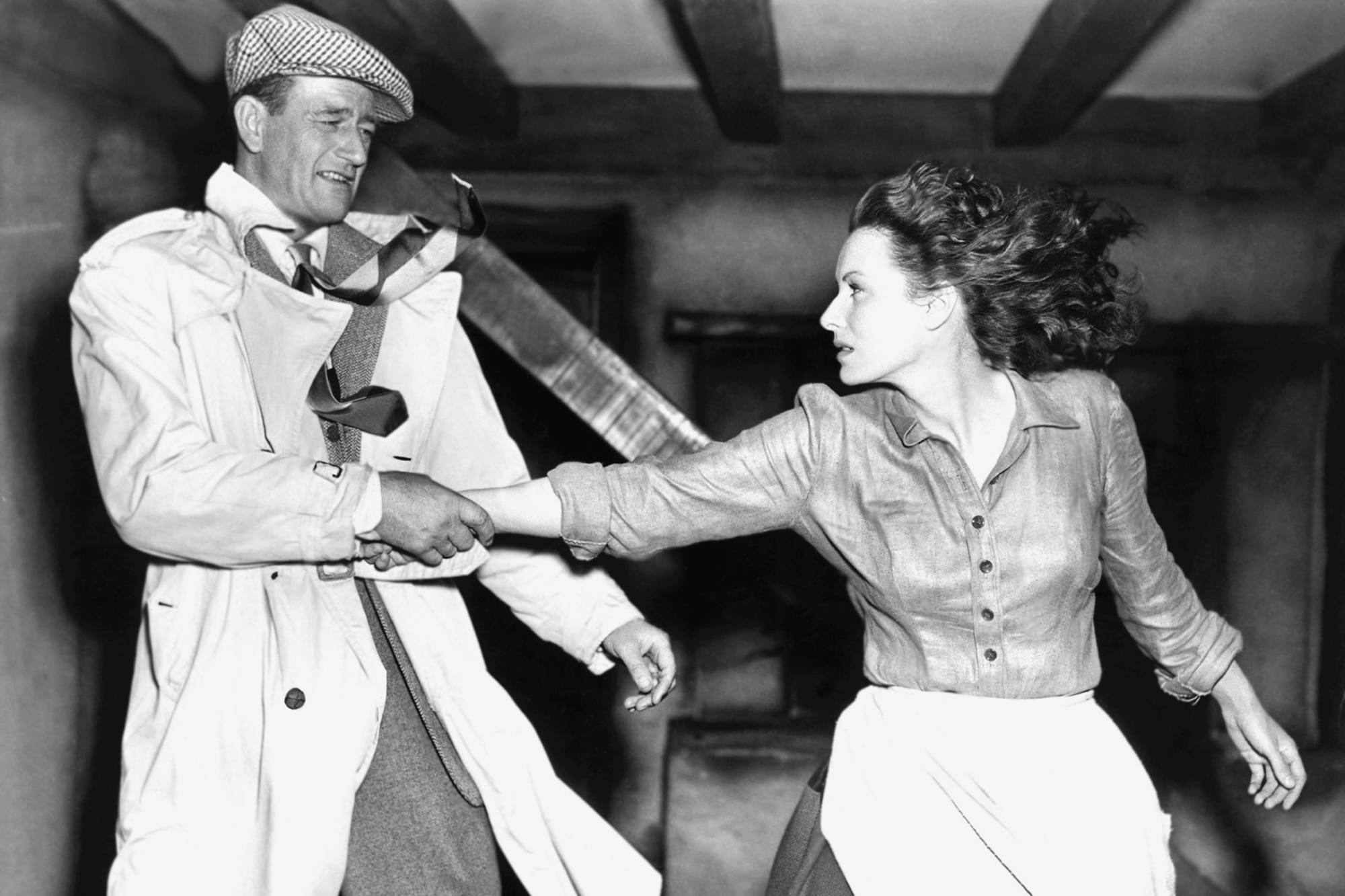 'The Quiet Man' John Wayne as Sean Thornton and Maureen O'Hara as Mary Kate Danaher. Wayne is yanking O'Hara back by her wrist.