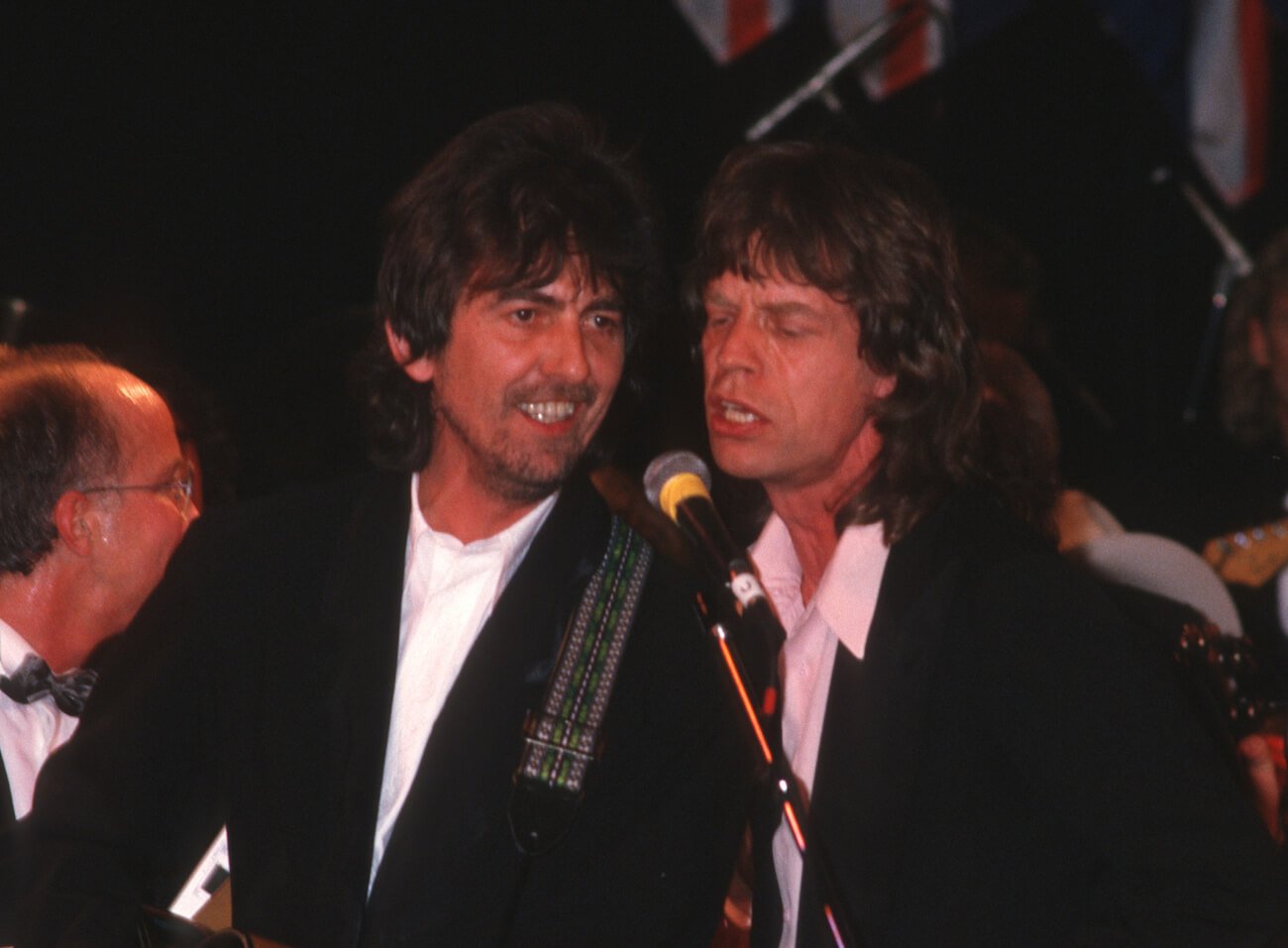 George Harrison of The Beatles and Mick Jagger of The Rolling Stones performing at the 1988 Rock & Roll Hall of Fame induction ceremony.