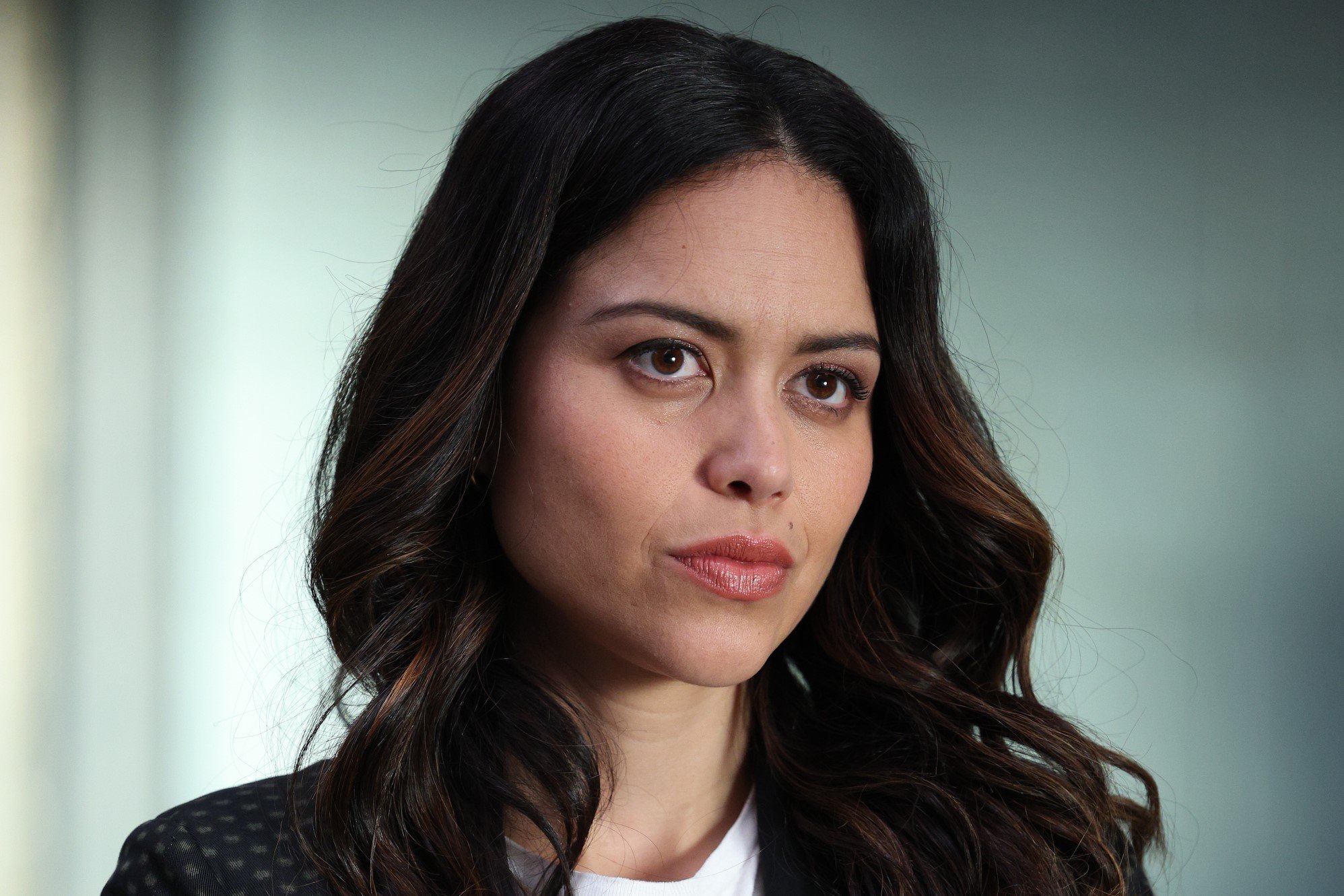 Alyssa Diaz, who stars as Angela Lopez in 'The Rookie' Season 5 Episode 15 on ABC, wears a black suit over a white shirt.