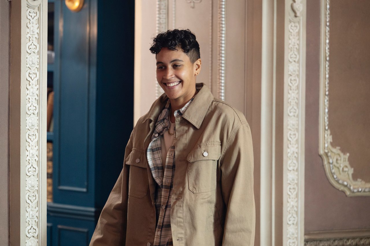 Andie Thurmond stands up and smiles in the dining room of 'The Traitors'.