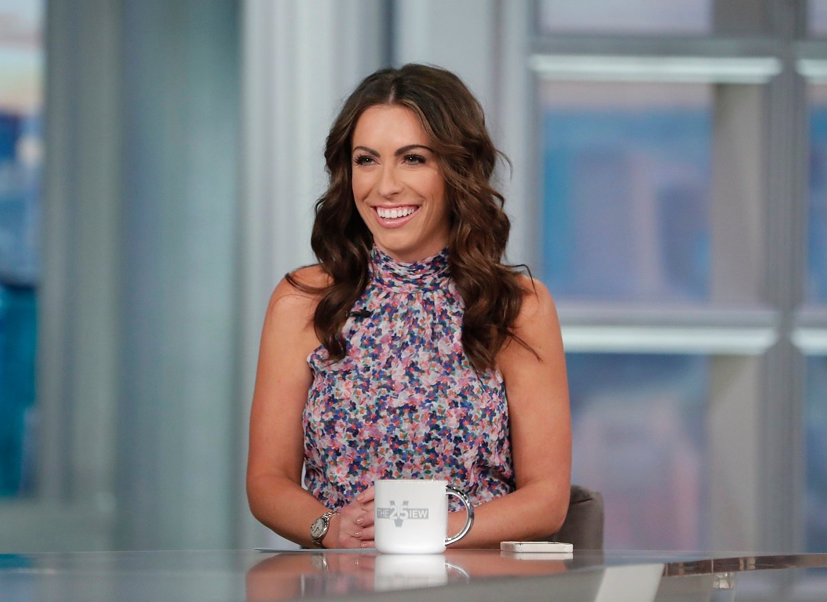 'The View' co-host Alyssa Farah Griffin in a floral print dress; smiles on set of the ABC talk show.