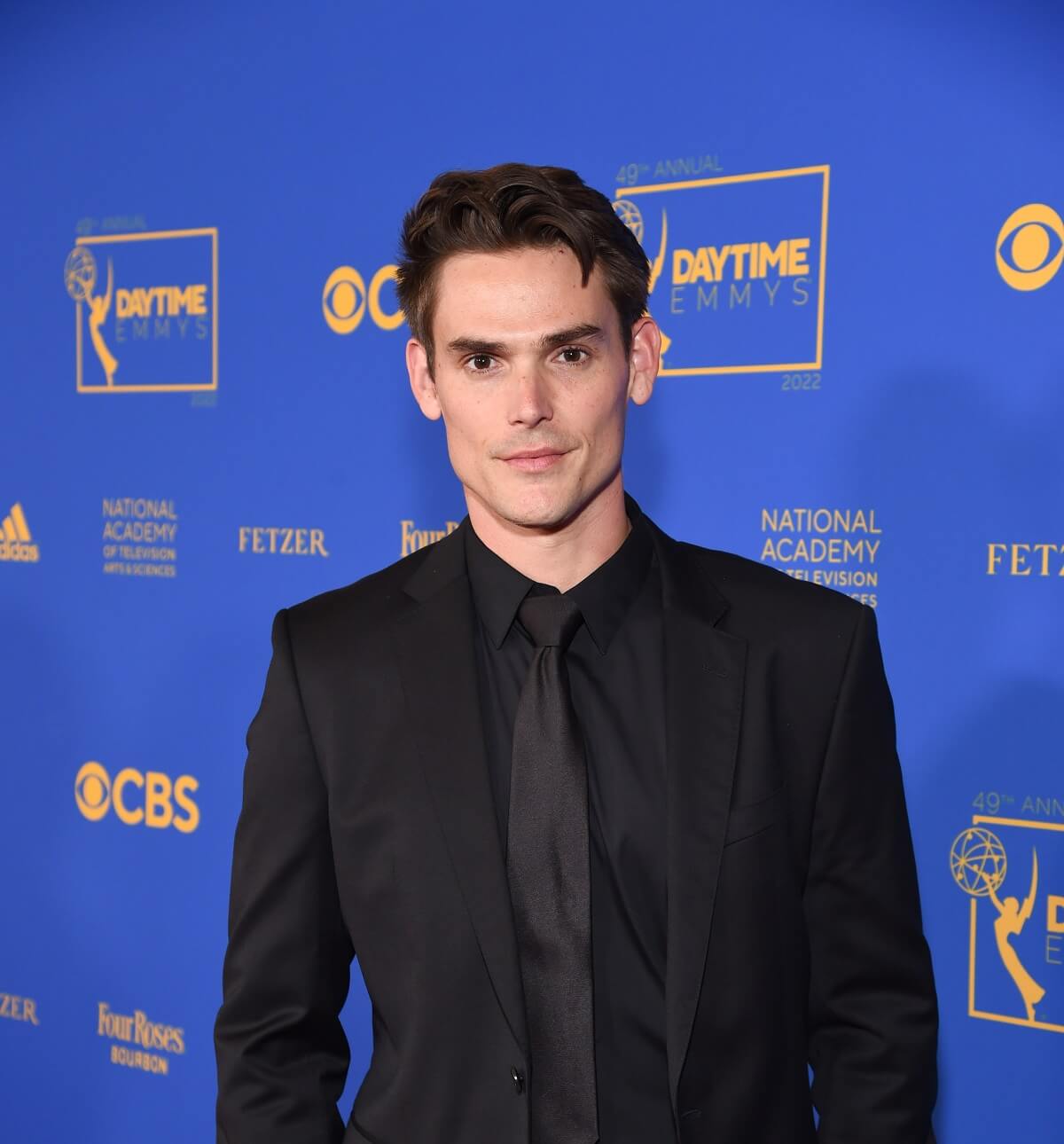 'The Young and the Restless' star Mark Grossman in a black suit posing on the red carpet of the 2022 Daytime Emmys.