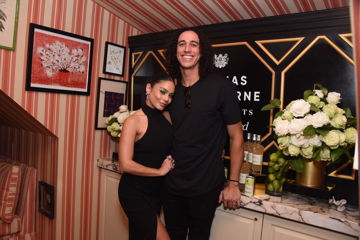 Vanessa Hudgens and Cole Tucker standing with their arms around each other