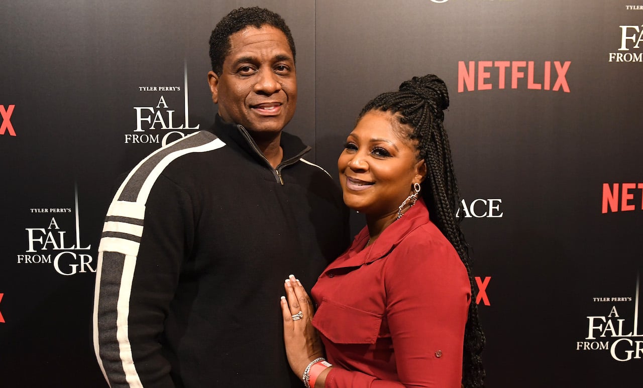 Von Scales and Trina Braxton pose on the red carpet with her hand on his chest