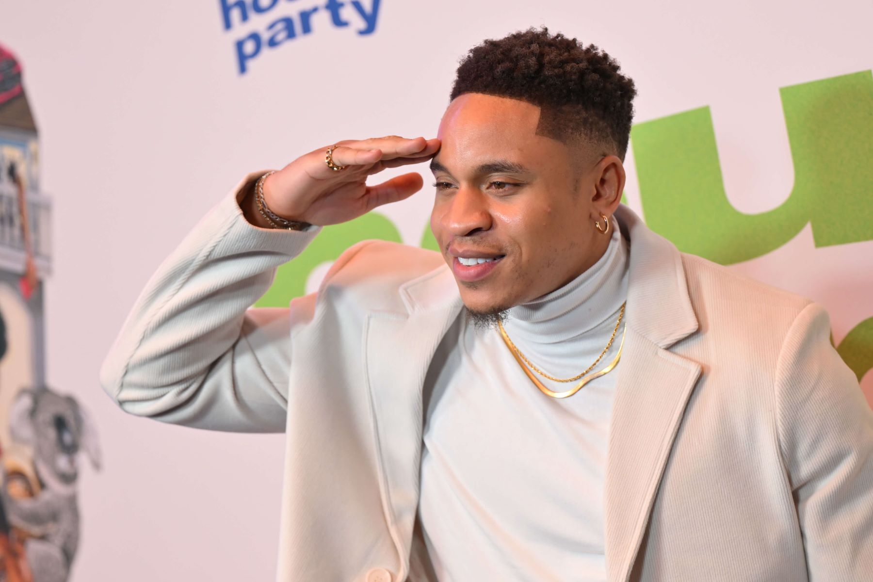Rotimi, who stars as Charles in 'Will Trent' on ABC, wears a white suit jacket over a white turtleneck and gold chain necklace.
