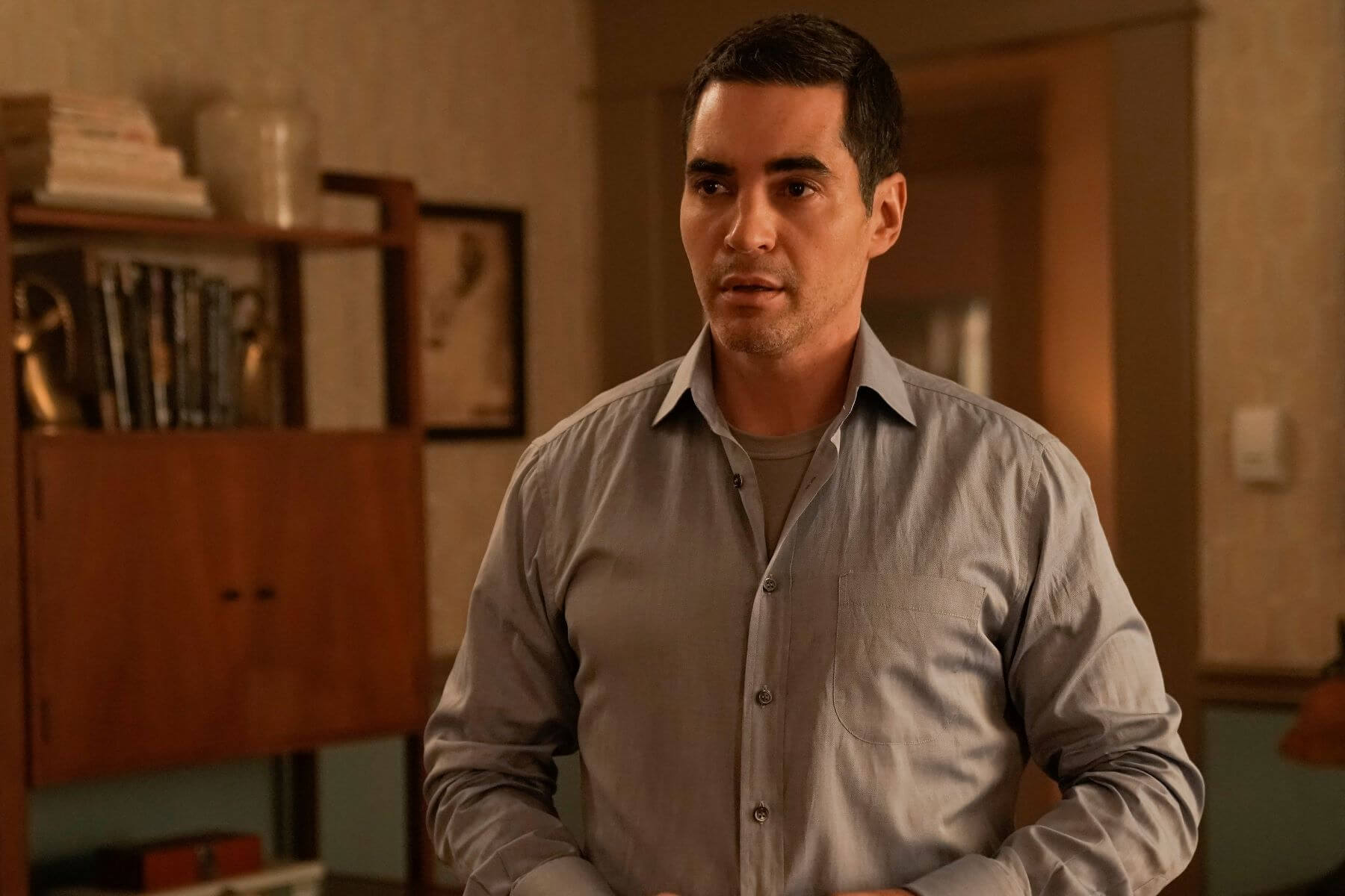 Ramón Rodríguez, in character as Will Trent in 'Will Trent' Season 1 Episode 7, wears a light blue button-up shirt over a gray shirt.