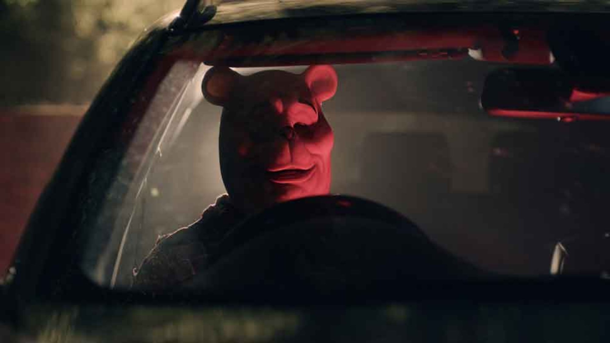 'Winnie the Pooh: Blood and Honey' Craig David Dowsett as Pooh Bear sitting in a car with red lighting