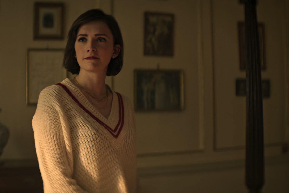 In You Season 4, Kate wears a cream-colored sweater with a red stripe.