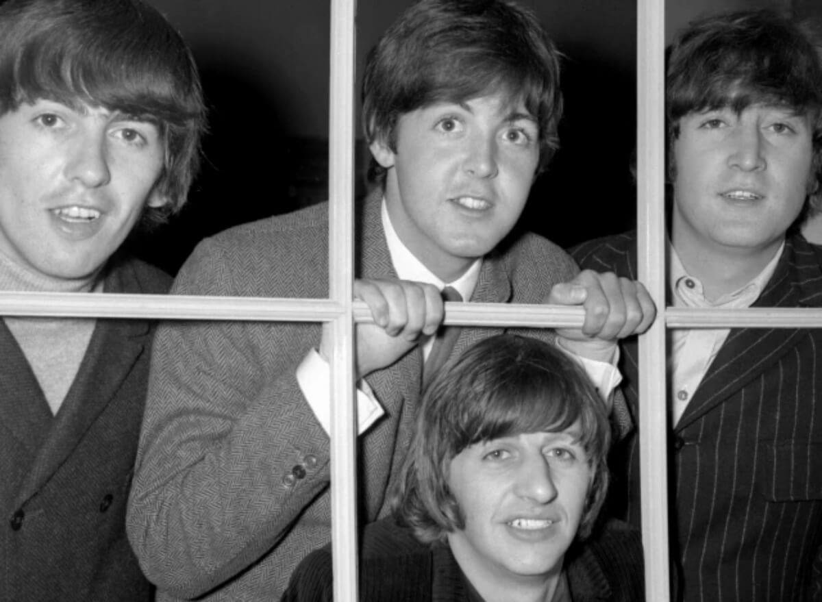 The Beatles looking through a window