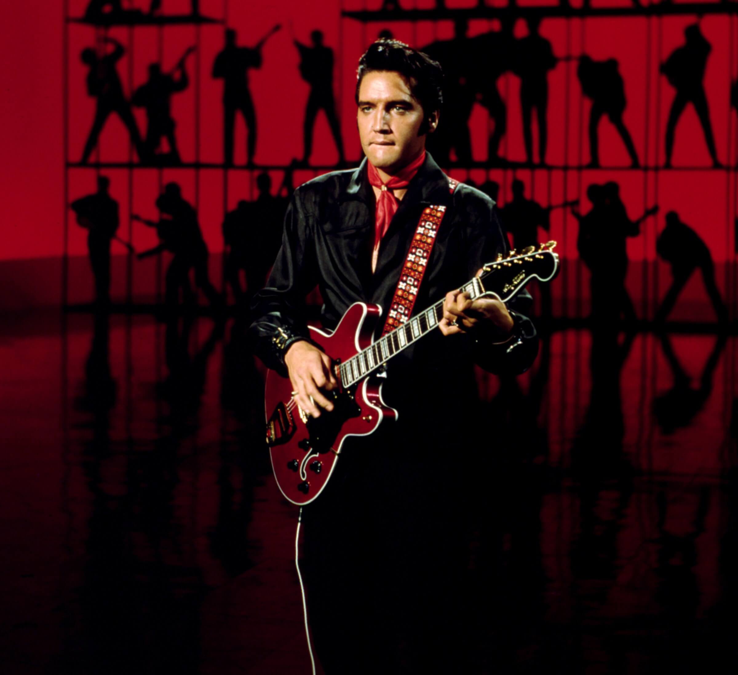 Elvis Presley playing songs with a guitar
