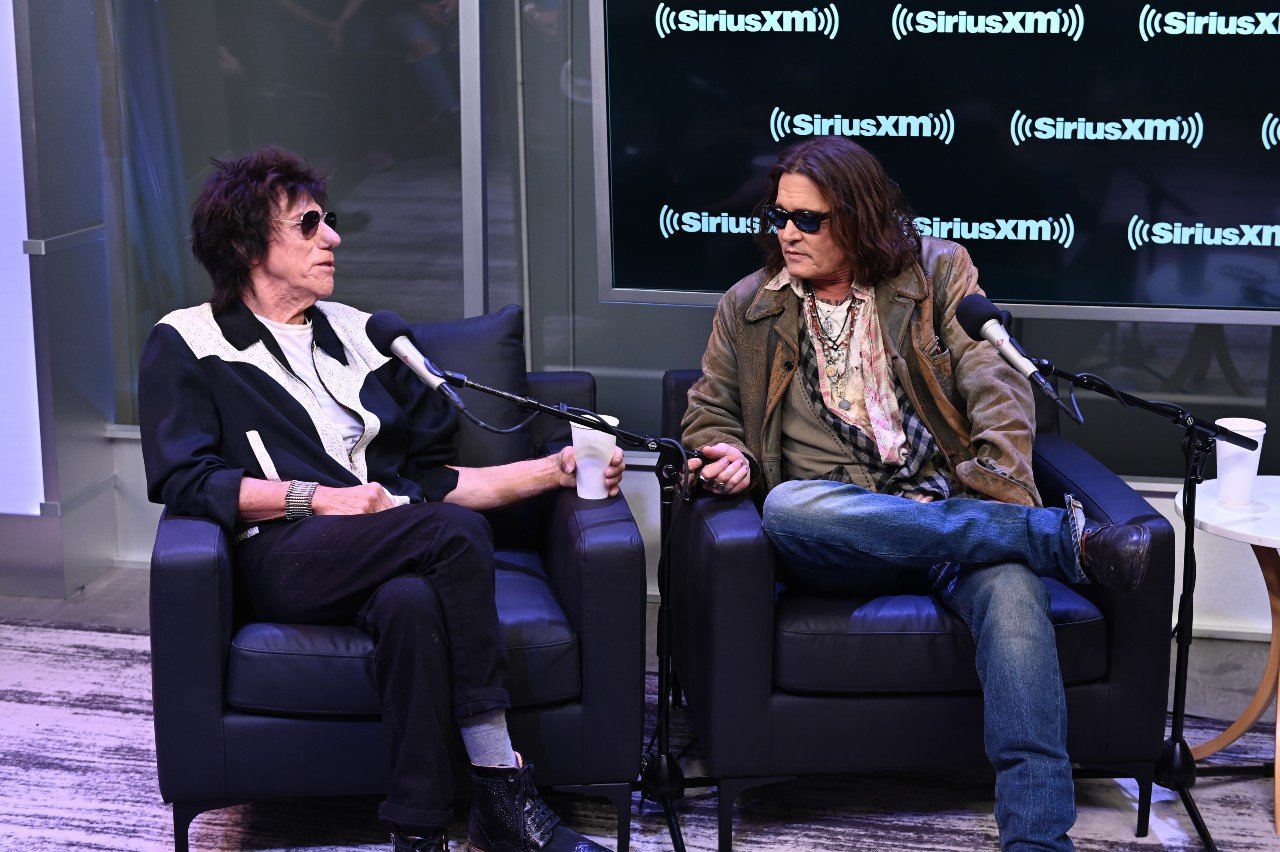 Jeff Beck and Johnny Depp sit next to each other and talk during an interview. 