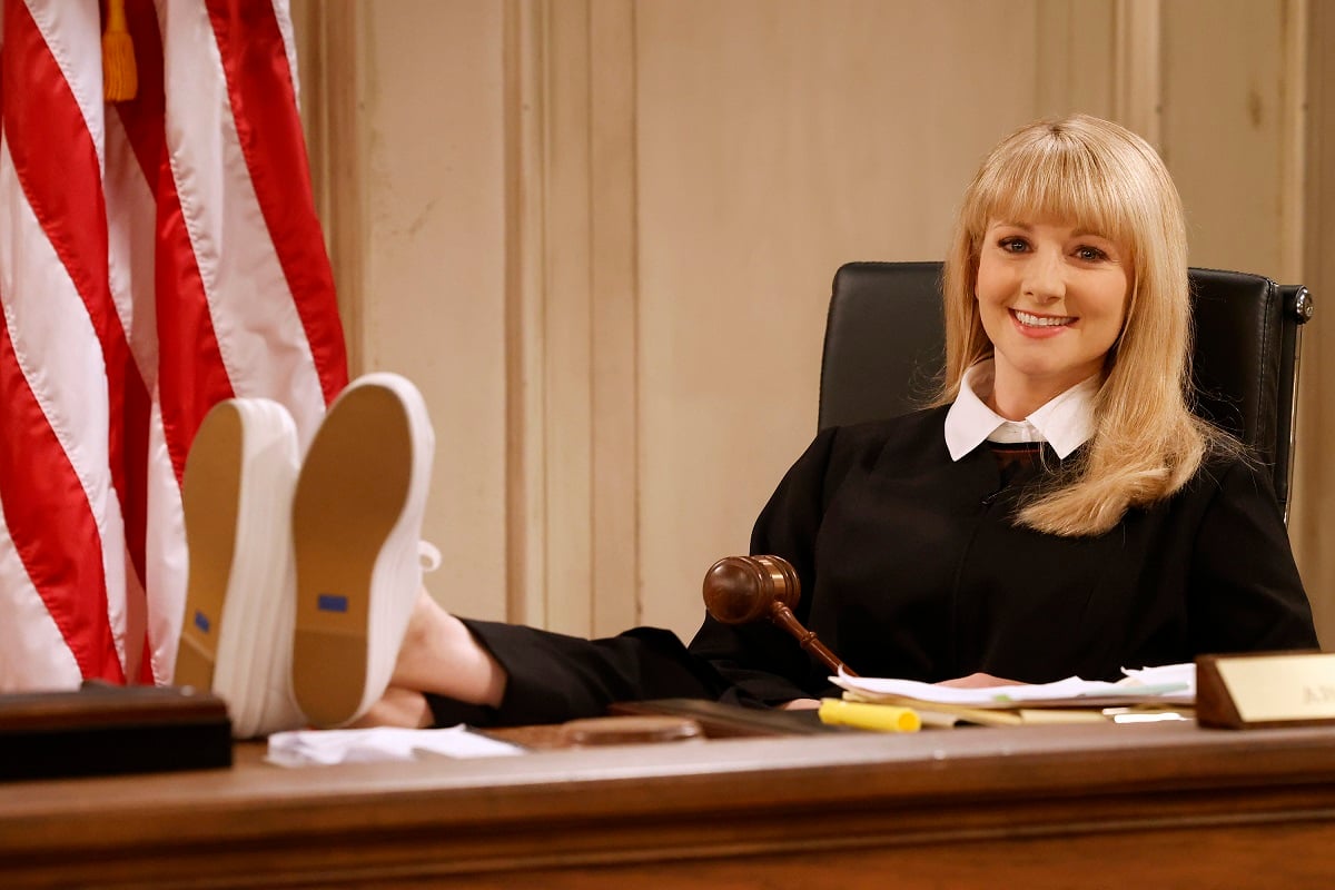 Melissa Rauch as Abby Stone sits with her feet up in the pilot episode of 'Night Court'