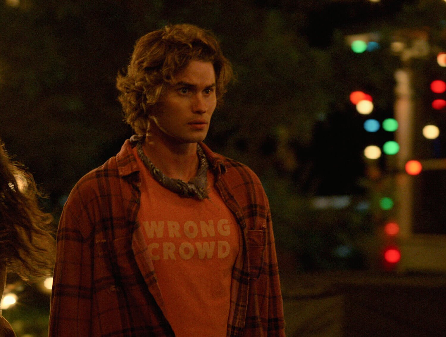 Outer Banks Season 2: Chase Stokes as John B wearing a red flannel, T-shirt, and the alleged shroud bandana around his neck