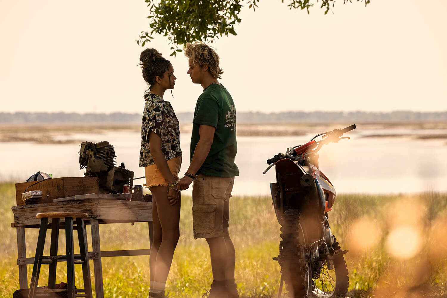 Madison Bailey as Kiara and Rudy Pankow as JJ looking in each other's eyes and holding hands in Outer Banks Season 3