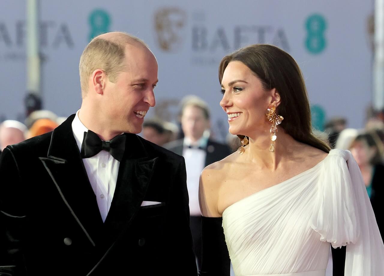 Prince William and Kate Middleton smile at each other. 