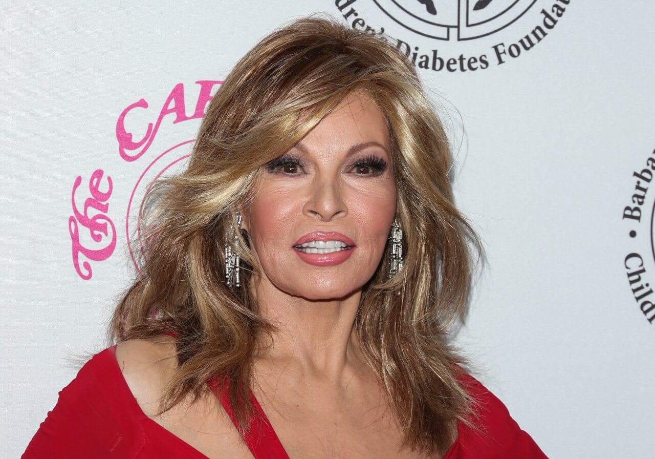 Raquel Welch poses in a red outfit.